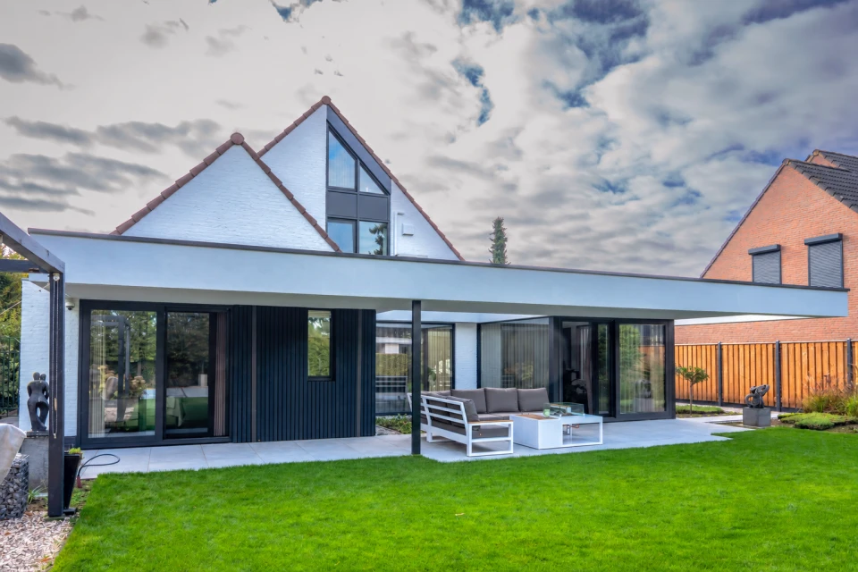 De gerealiseerde uitbouw en overdekte patio aan de tuinzijde in Heythuysen.: Luxe verbouwing Heythuysen, beeld 1
