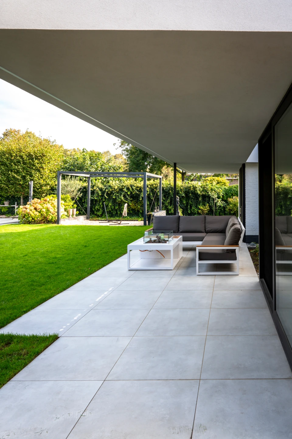 De overdekte patio met zicht op de tuin in Heythuysen.: Luxe verbouwing Heythuysen, beeld 4
