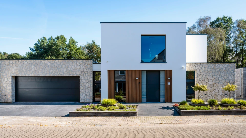 De vernieuwde voorgevel van de woning in Asten, met witte afwerking en natuursteen.: Gevelrenovatie Asten, beeld 1