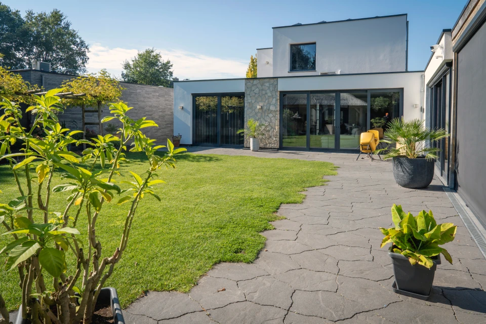 Zicht vanuit de tuin op de gerenoveerde woning in Asten.: Gevelrenovatie Asten, beeld 4