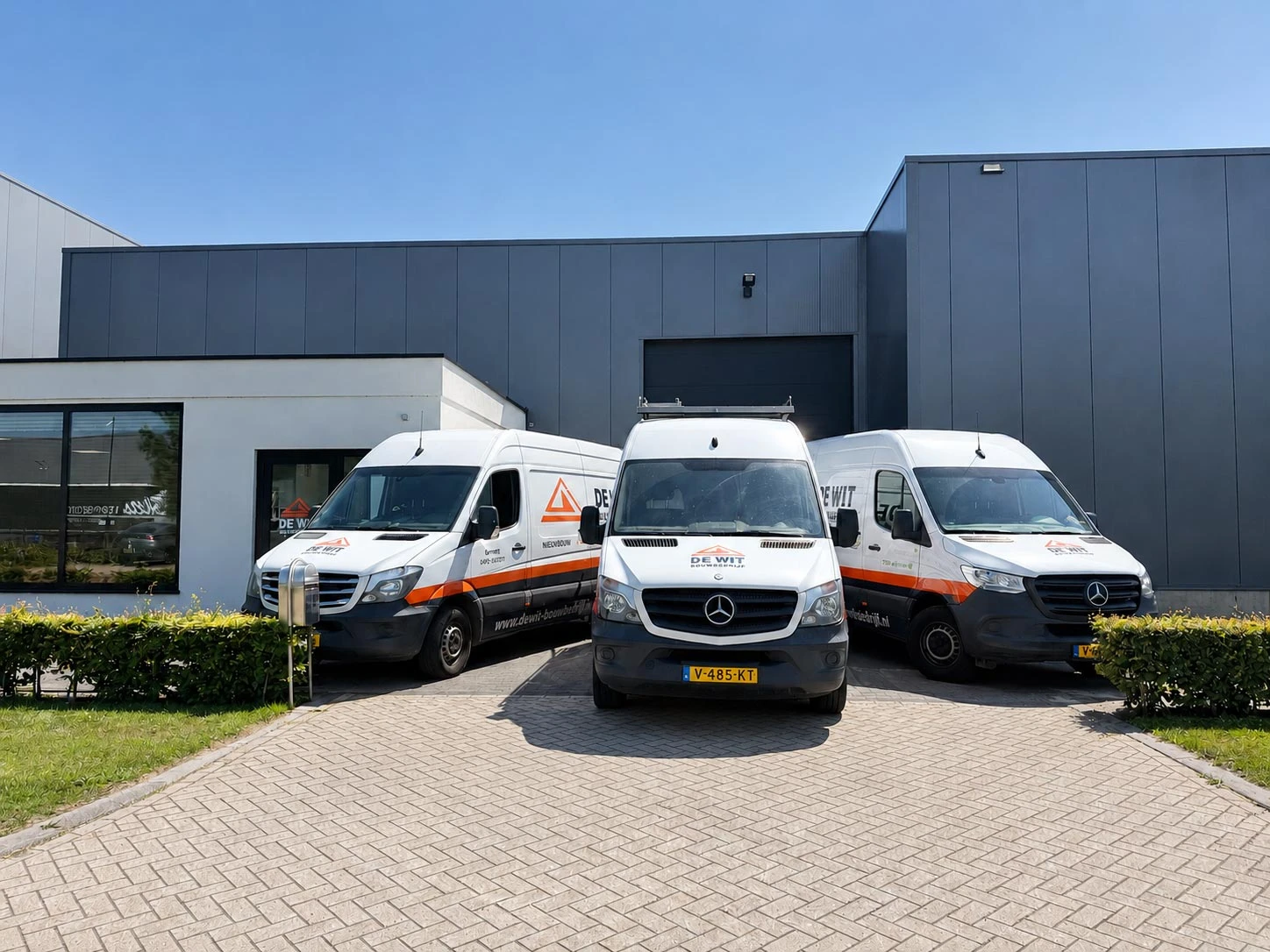 Drie bedrijfsbussen van De Wit Bouwbedrijf voor het bedrijfspand in Gemert